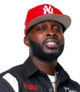 A man with a beard wearing a red ny hat and a black shirt.