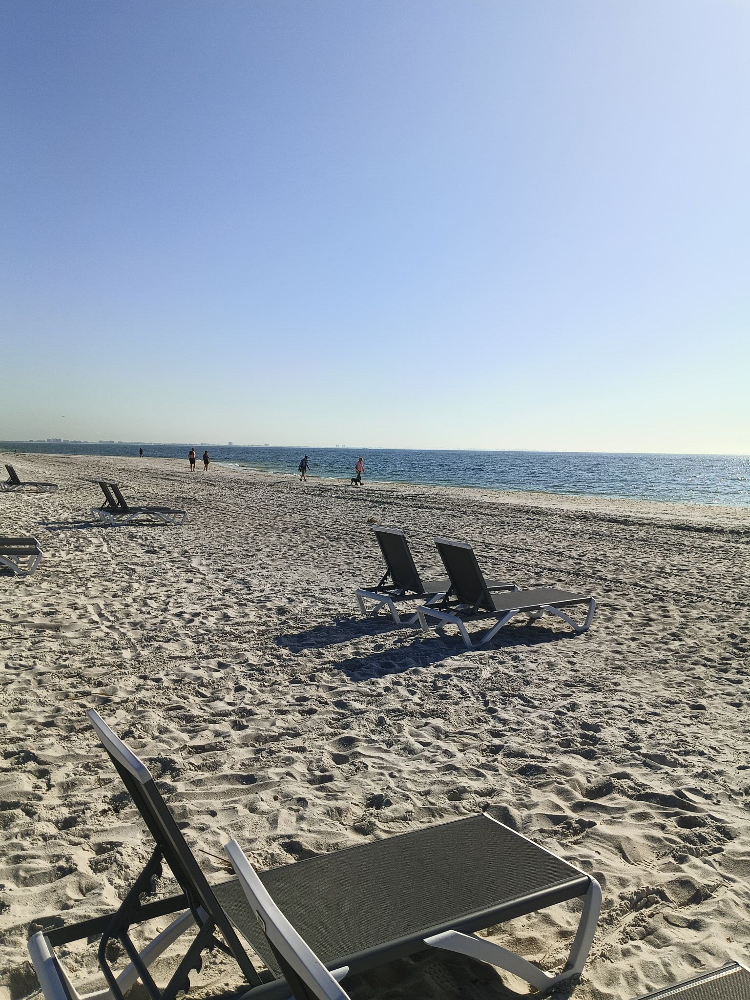 A beach with a lot of chairs and a view of the ocean.