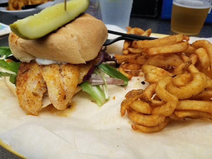 A sandwich with a pickle and french fries on a plate