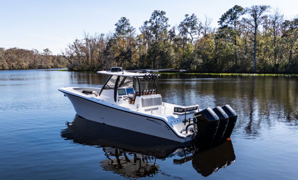 A white boat is floating on top of a body of water.