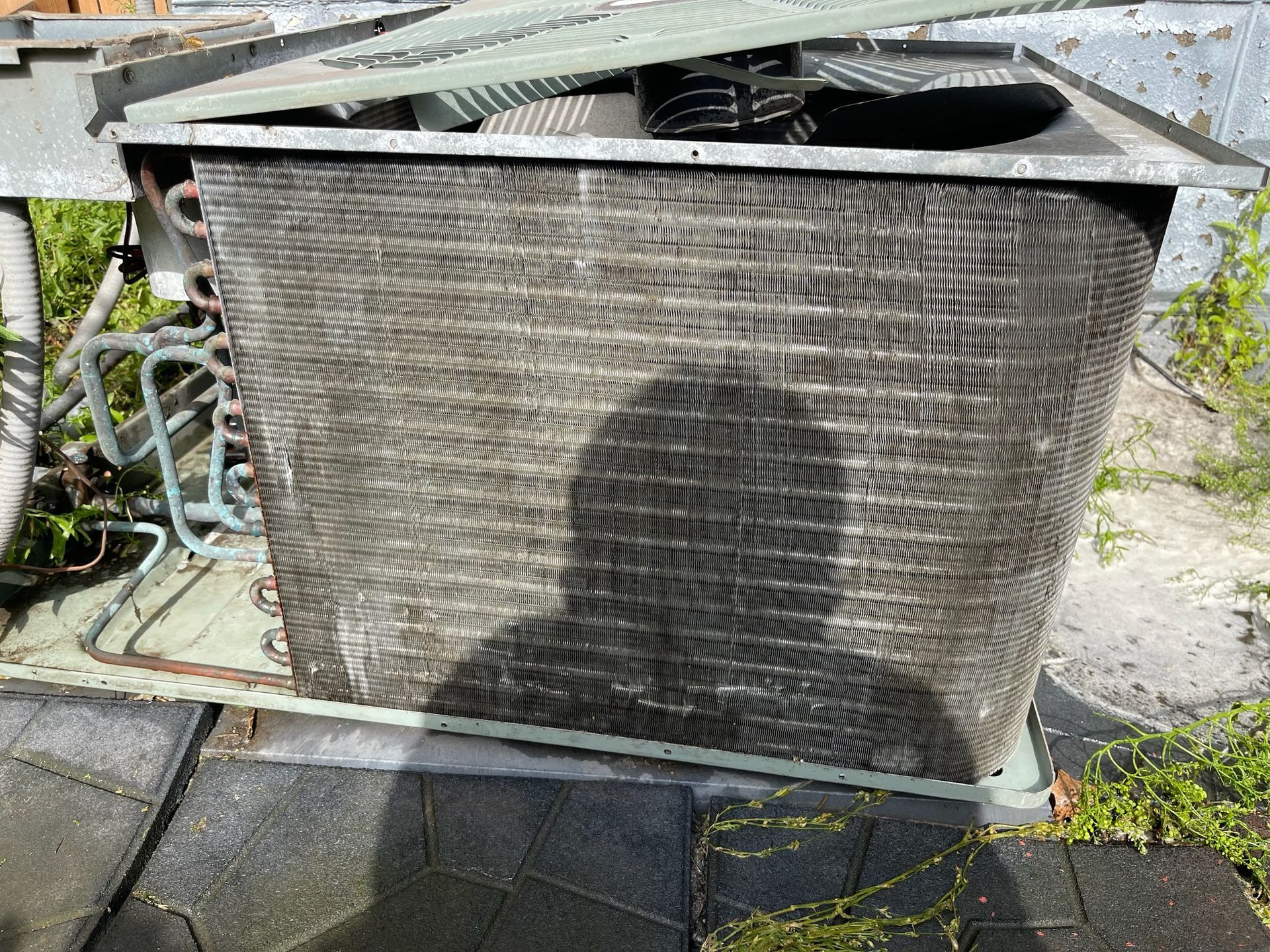 Air conditioning unit on a rooftop, gray with visible coils.