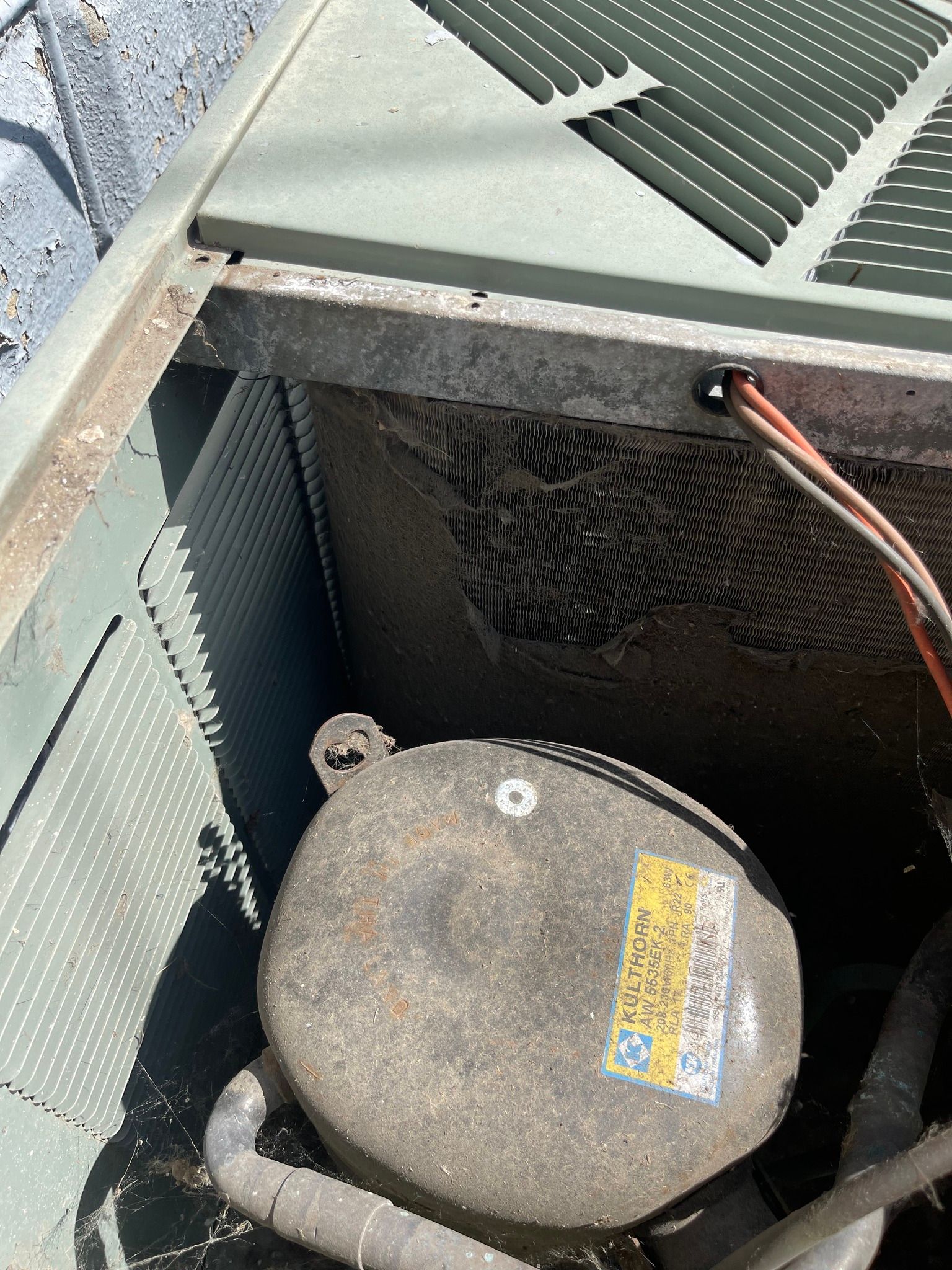 Air conditioning unit interior, with a compressor and dusty coils.