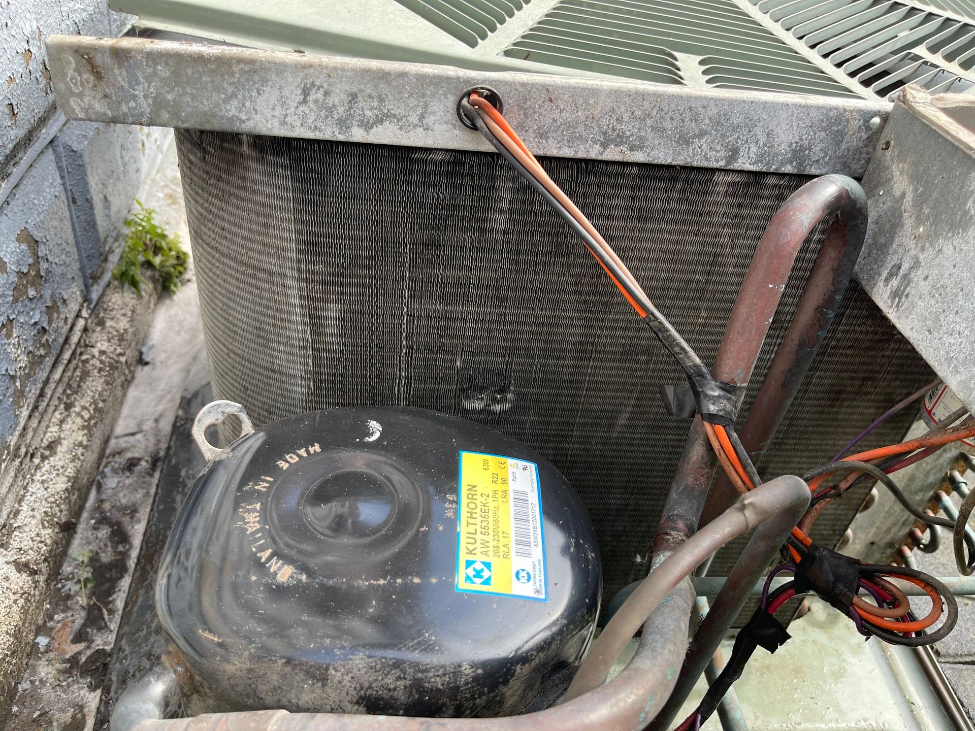 Exterior AC unit with dirty coils and compressor.