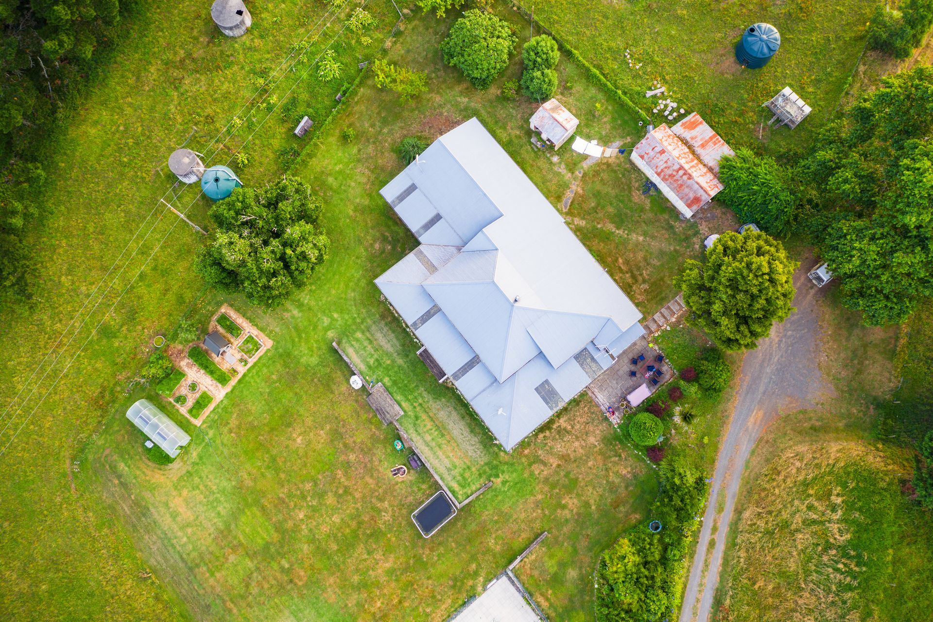 An aerial view of a house in the middle of a lush green field.
