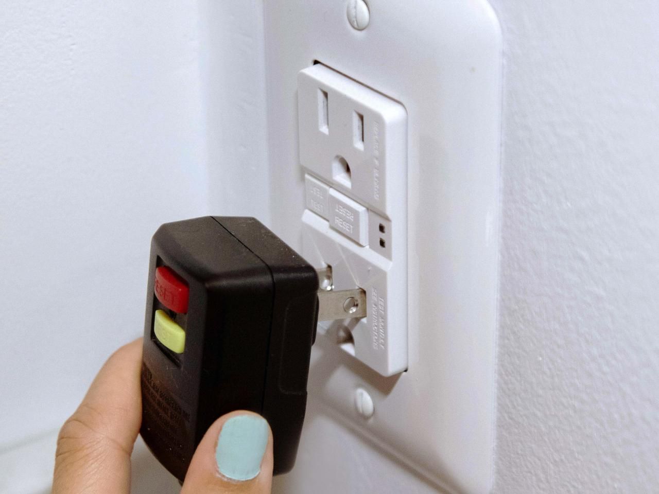 An electrician is working on an electrical box with a screwdriver.