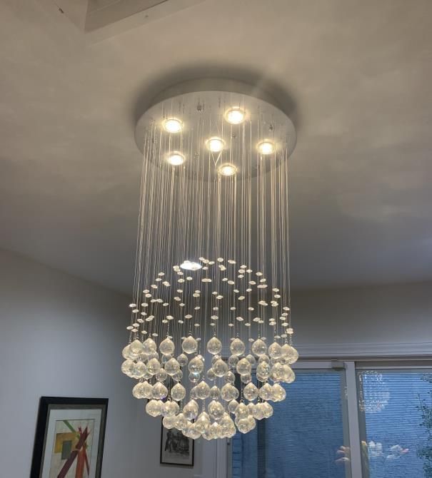 An electrician is working on an electrical box with a screwdriver.