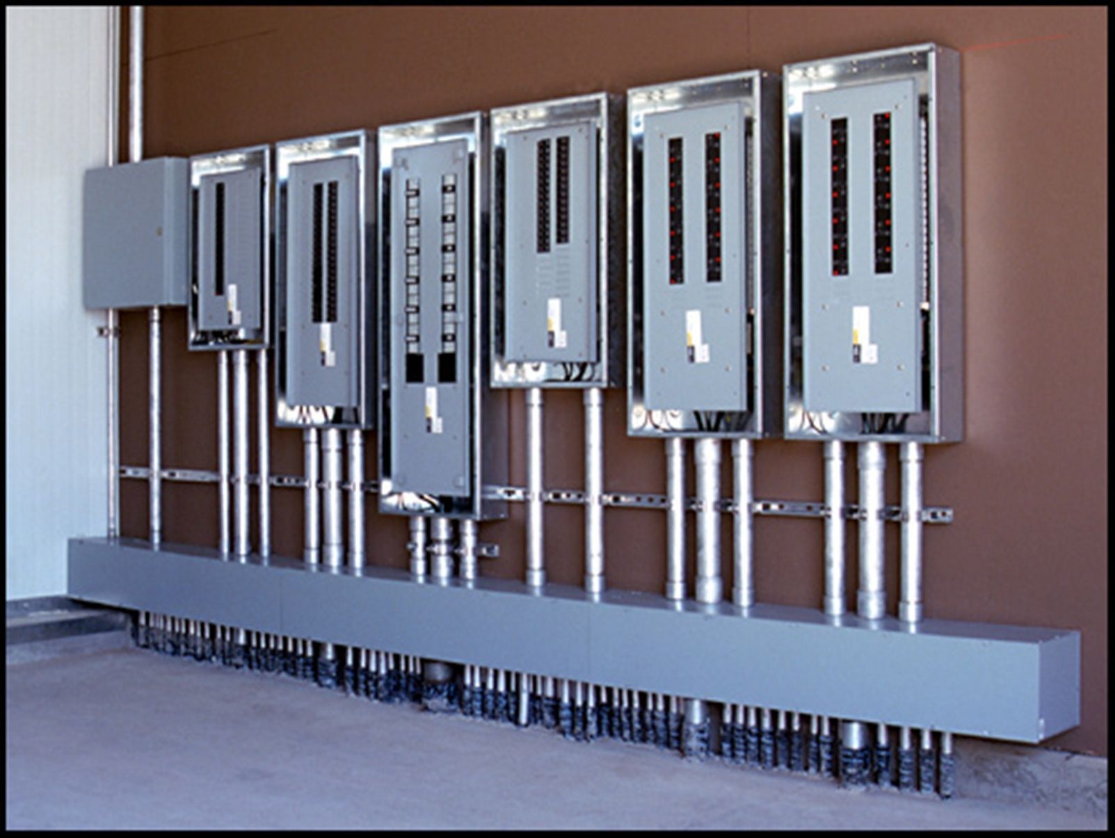 An electrician is working on an electrical box with a screwdriver.