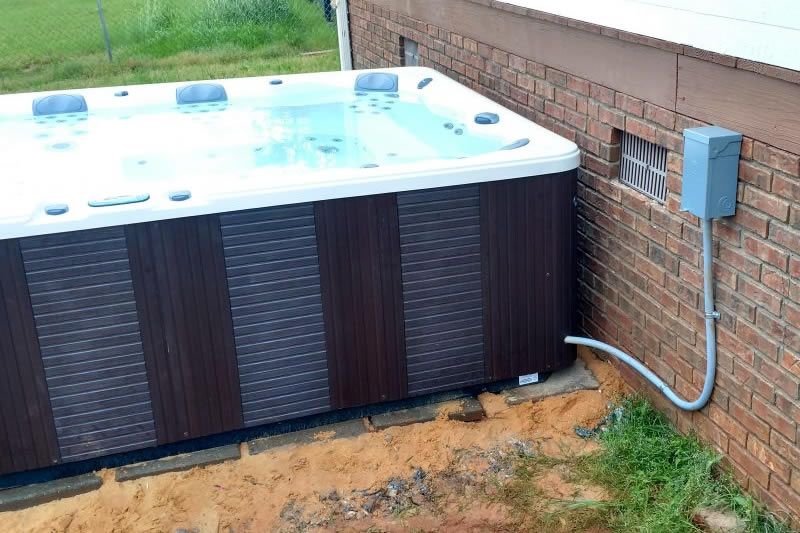 An electrician is working on an electrical box with a screwdriver.