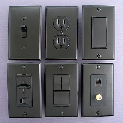 An electrician is working on an electrical box with a screwdriver.
