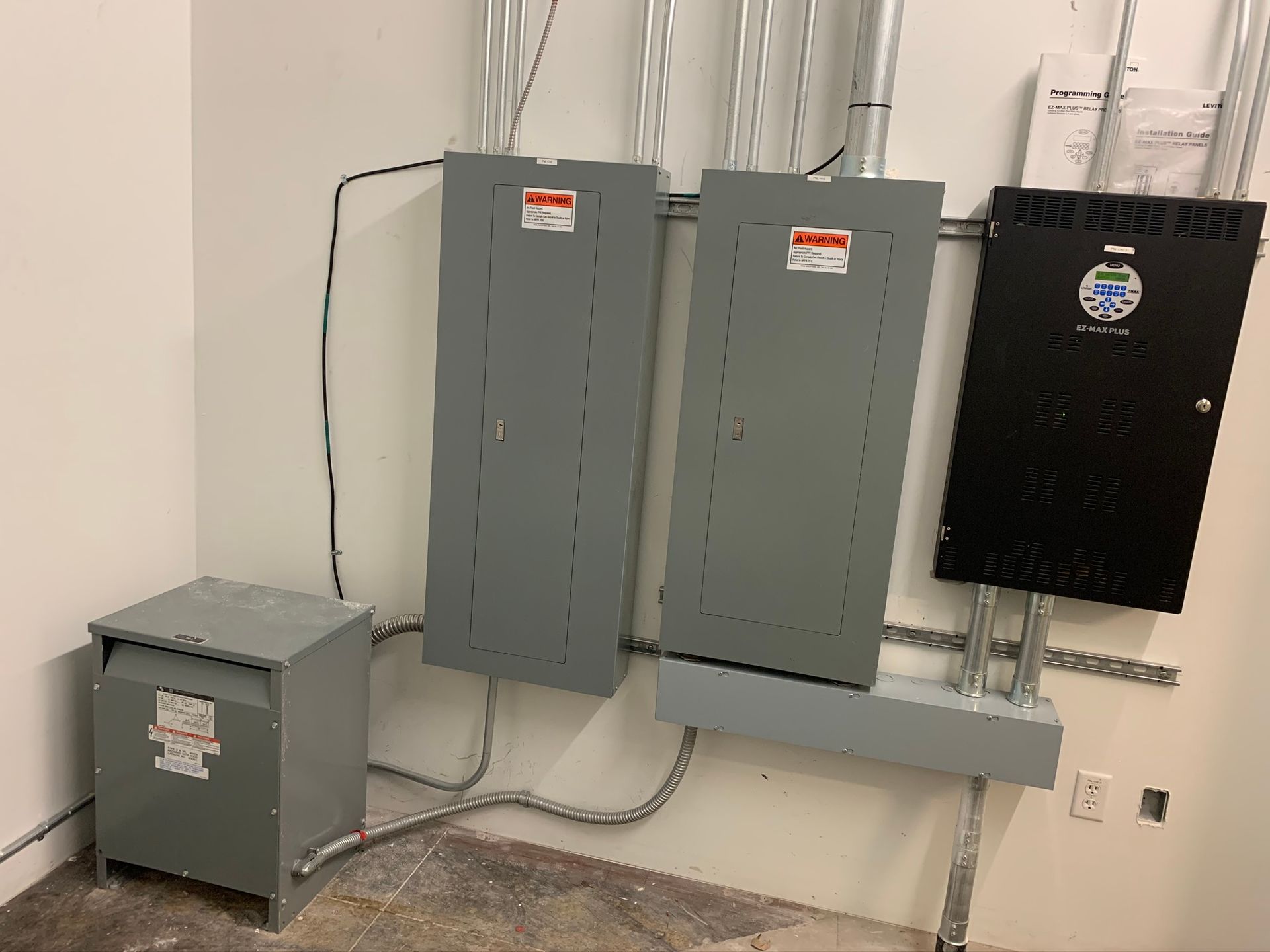 An electrician is working on an electrical box with a screwdriver.