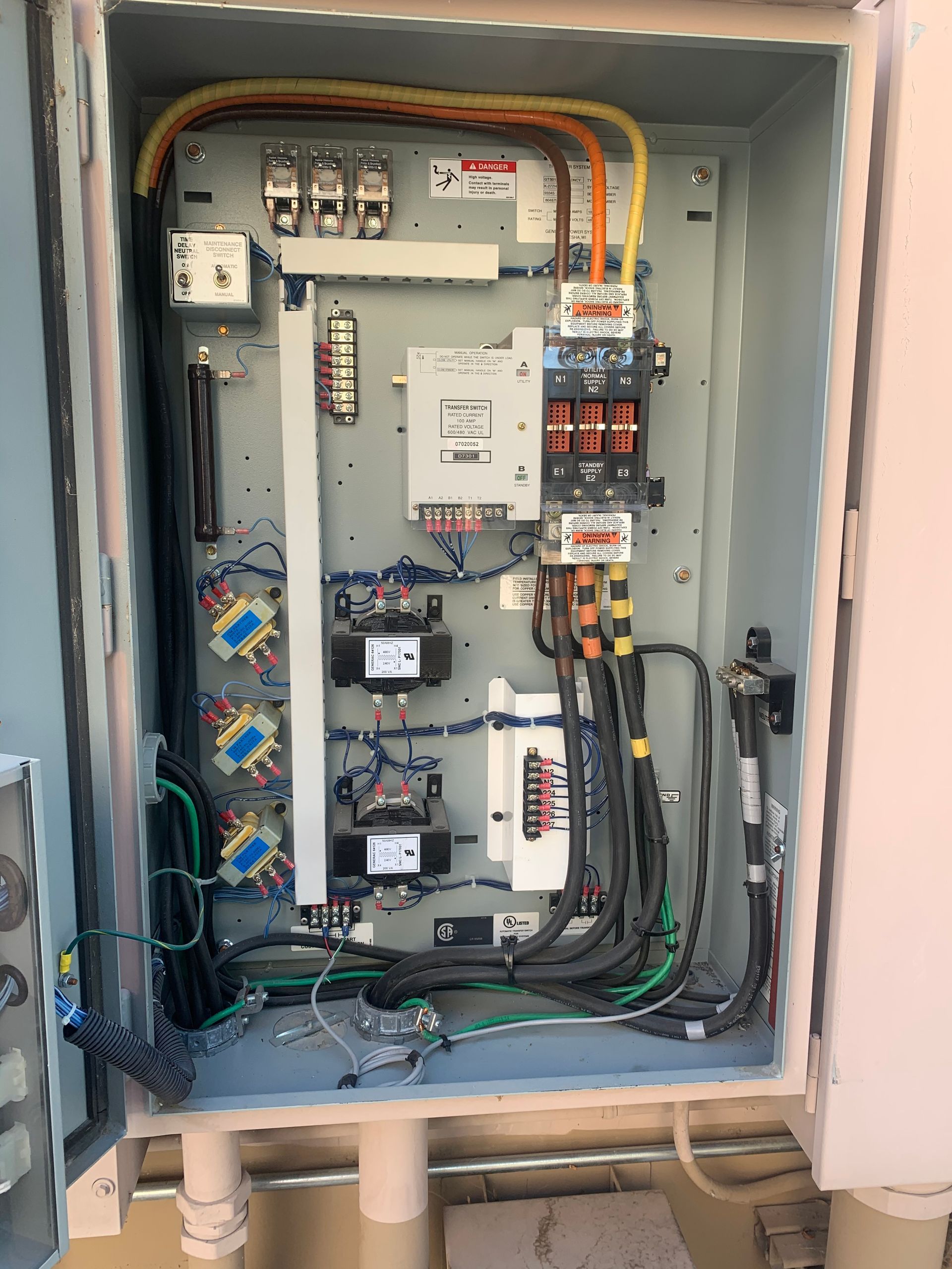 A man wearing gloves is working on an electrical box.