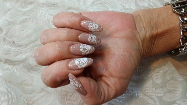 Die Hand einer Frau mit langen Nägeln und einer Uhr am Handgelenk.