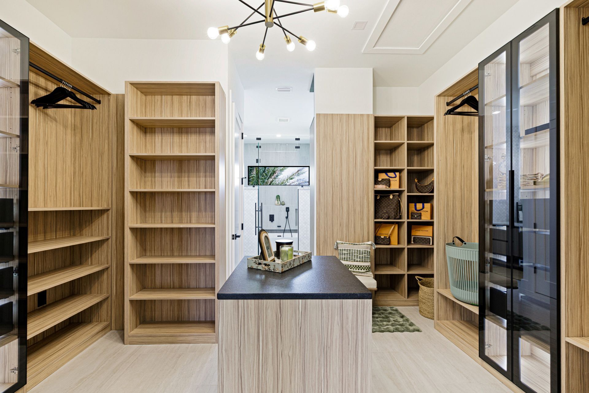 Walk-in closet with wooden shelving, center island, and glass-front cabinets.