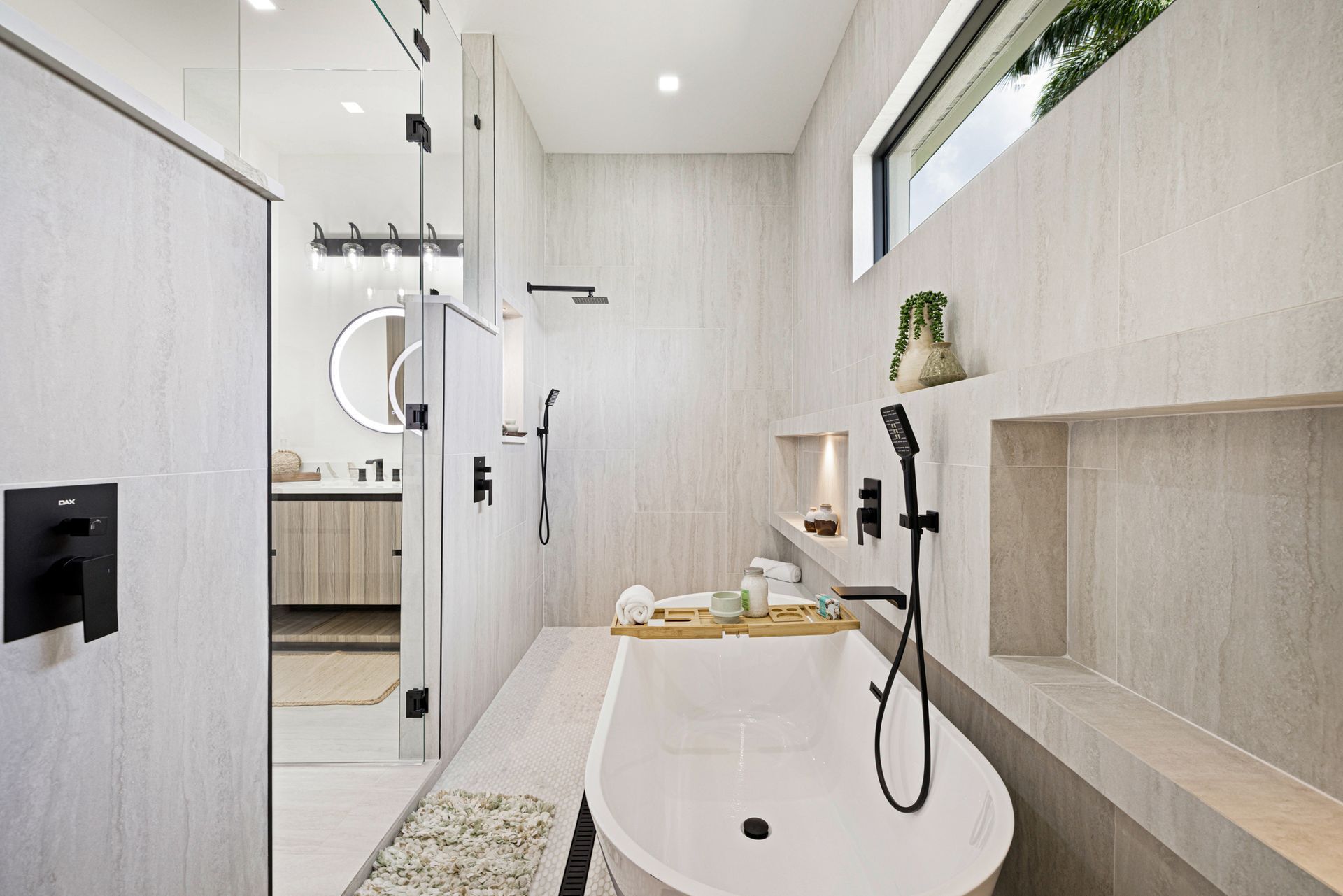 Modern, light-colored bathroom with a soaking tub, shower, and built-in shelves.