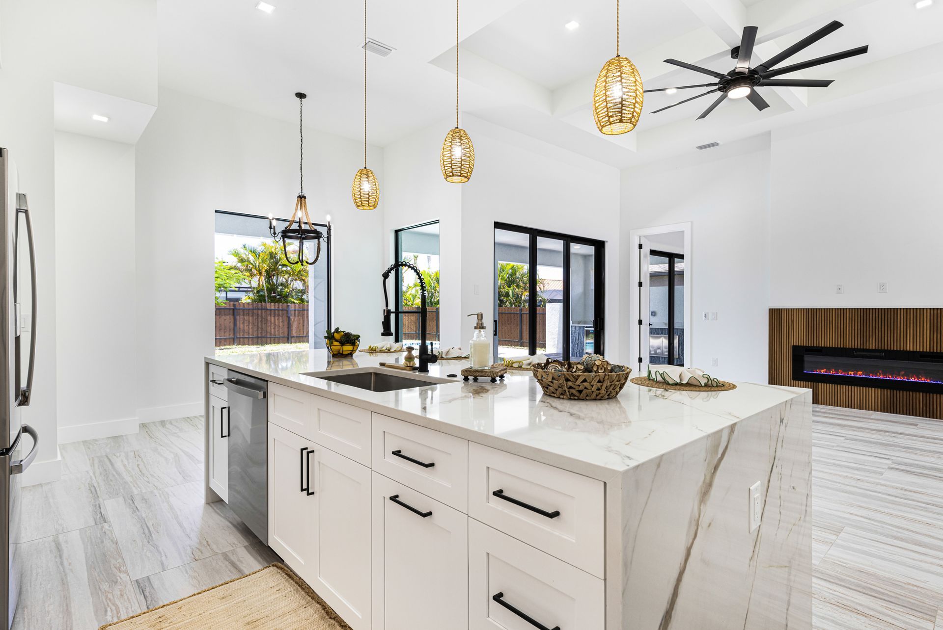 Bright, modern kitchen with a white island, black accents, and natural light.