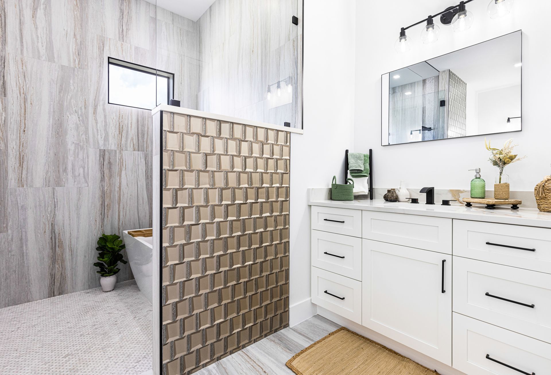 Modern bathroom with white cabinets, shower with patterned tiles, and decorative glass screen.