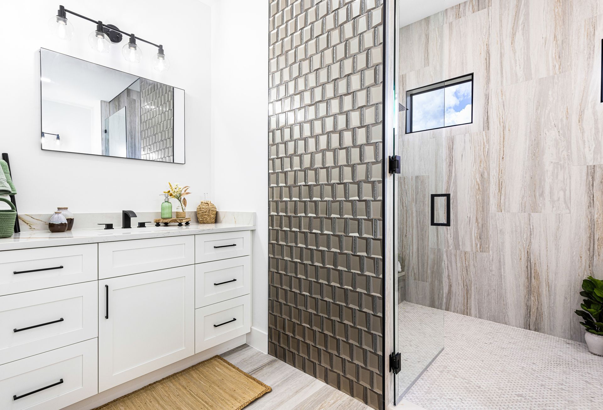 Modern bathroom with white vanity, glass shower, and patterned wall tile.