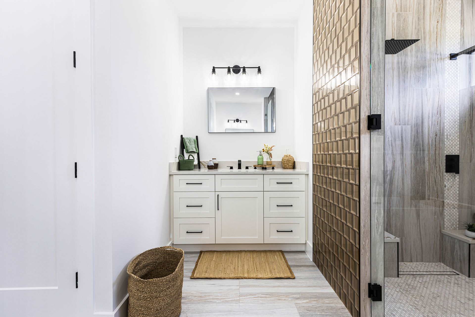 White bathroom with vanity, woven wall, and glass shower.