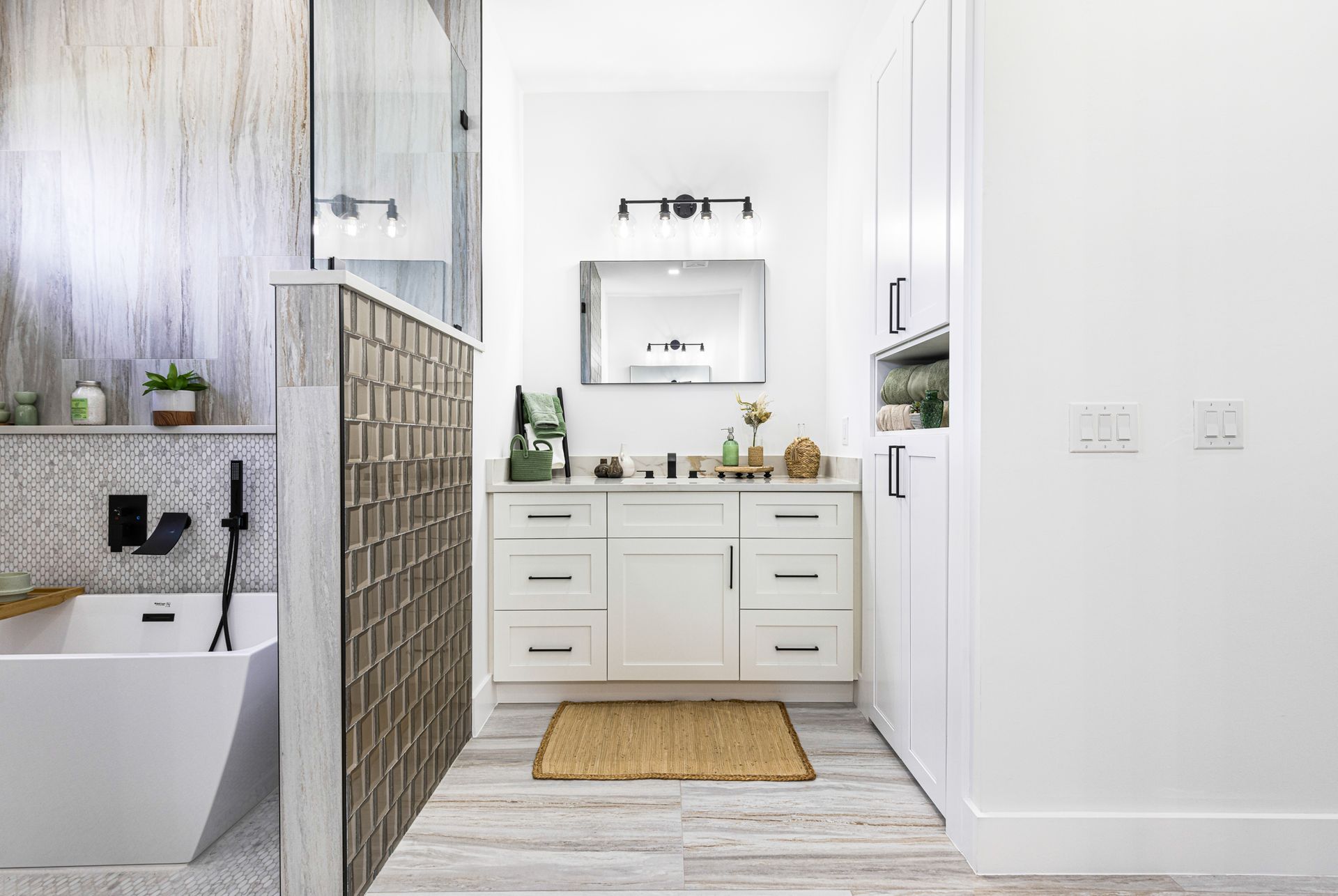 Modern white bathroom with a tub, vanity, and glass block wall.