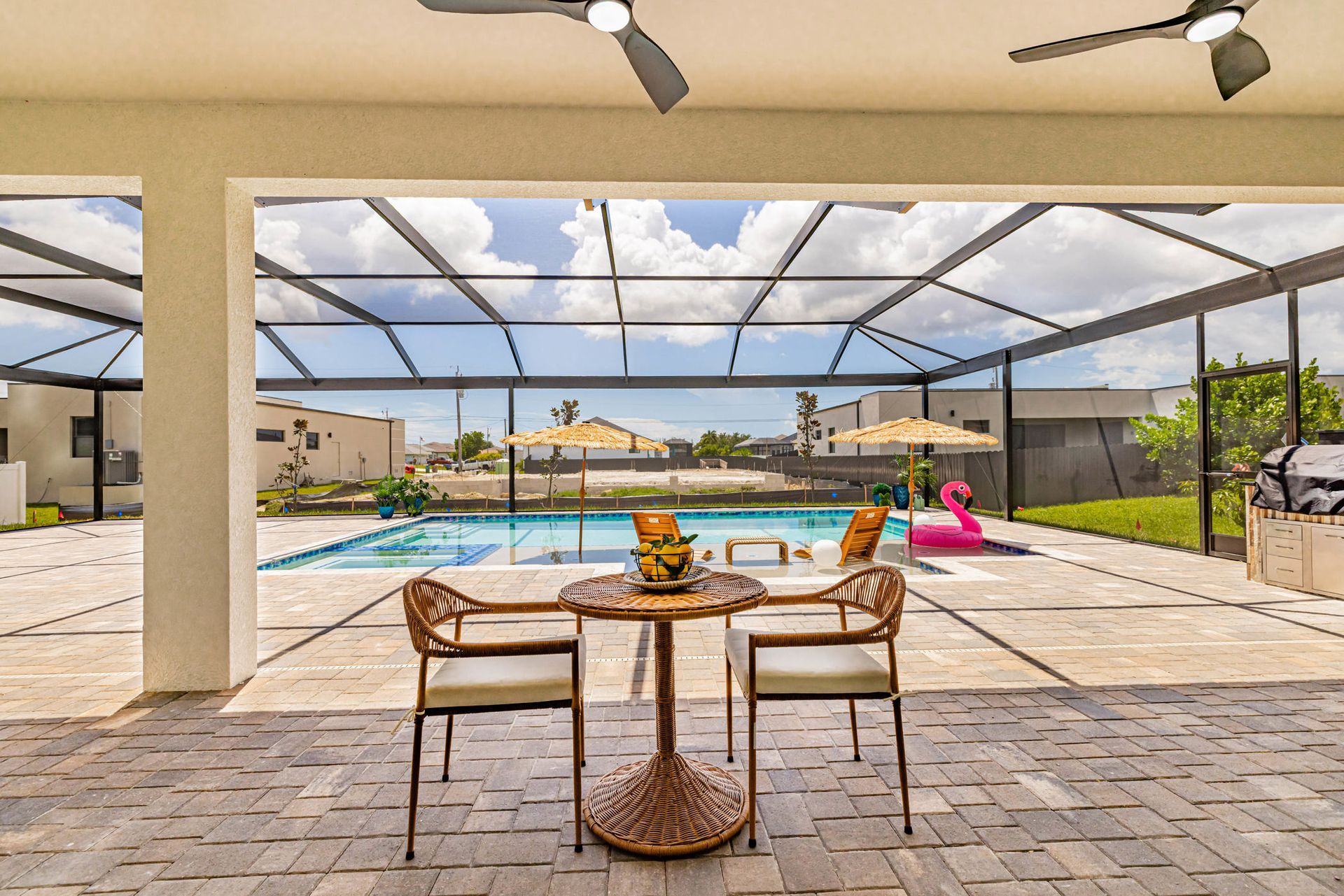Patio with wicker furniture overlooking a pool, sunny day.
