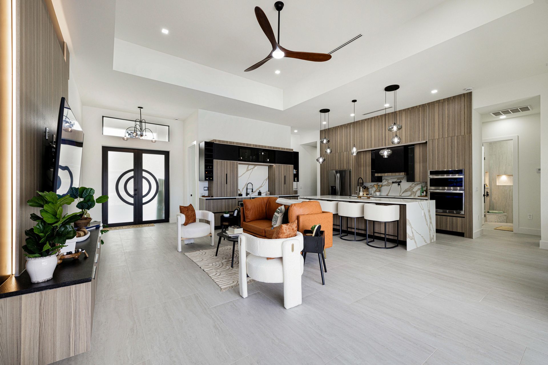 Modern open-concept living room with white walls, wood accents, and contemporary furniture.
