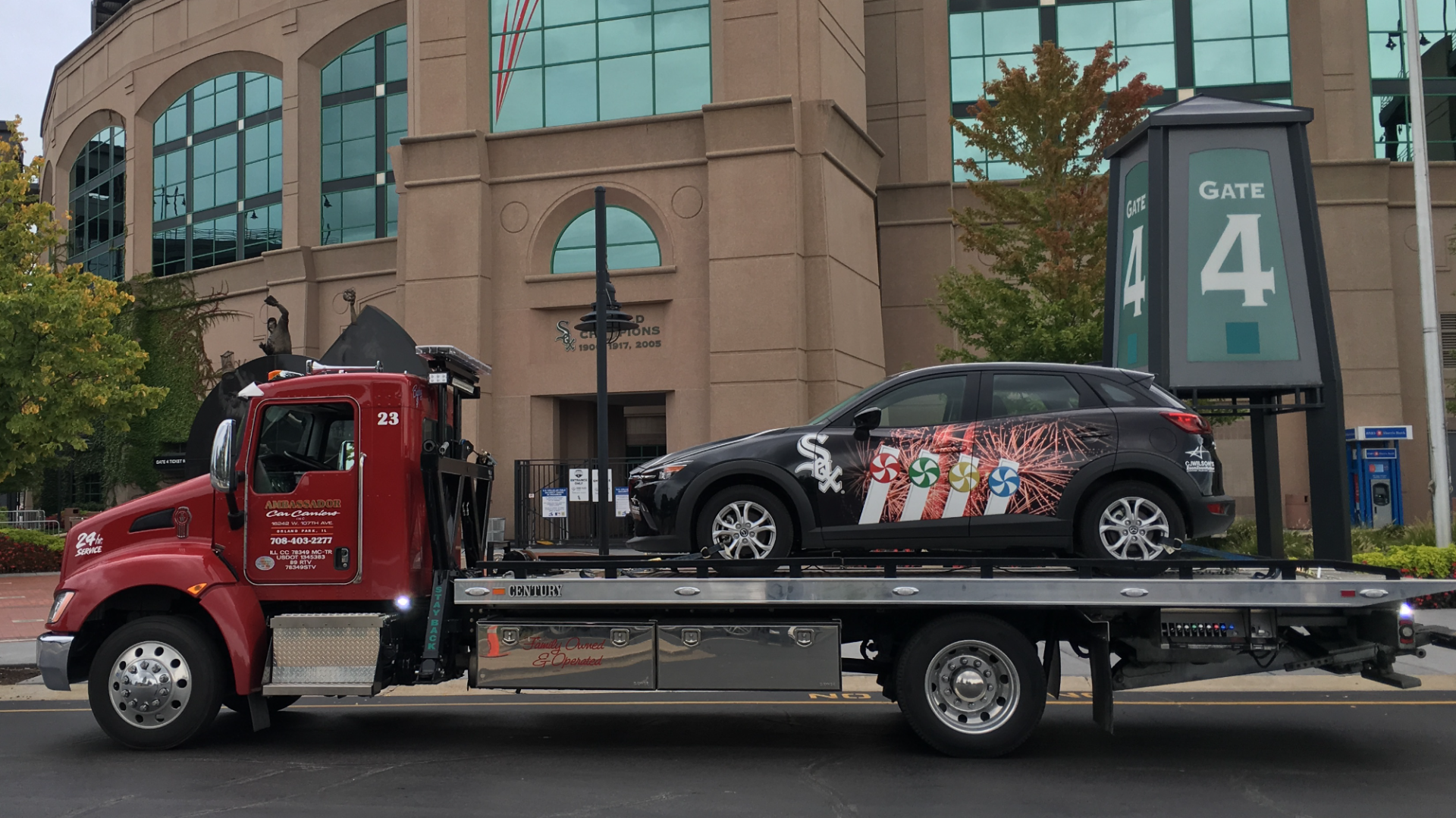 A tow truck is carrying a car on the back of it.