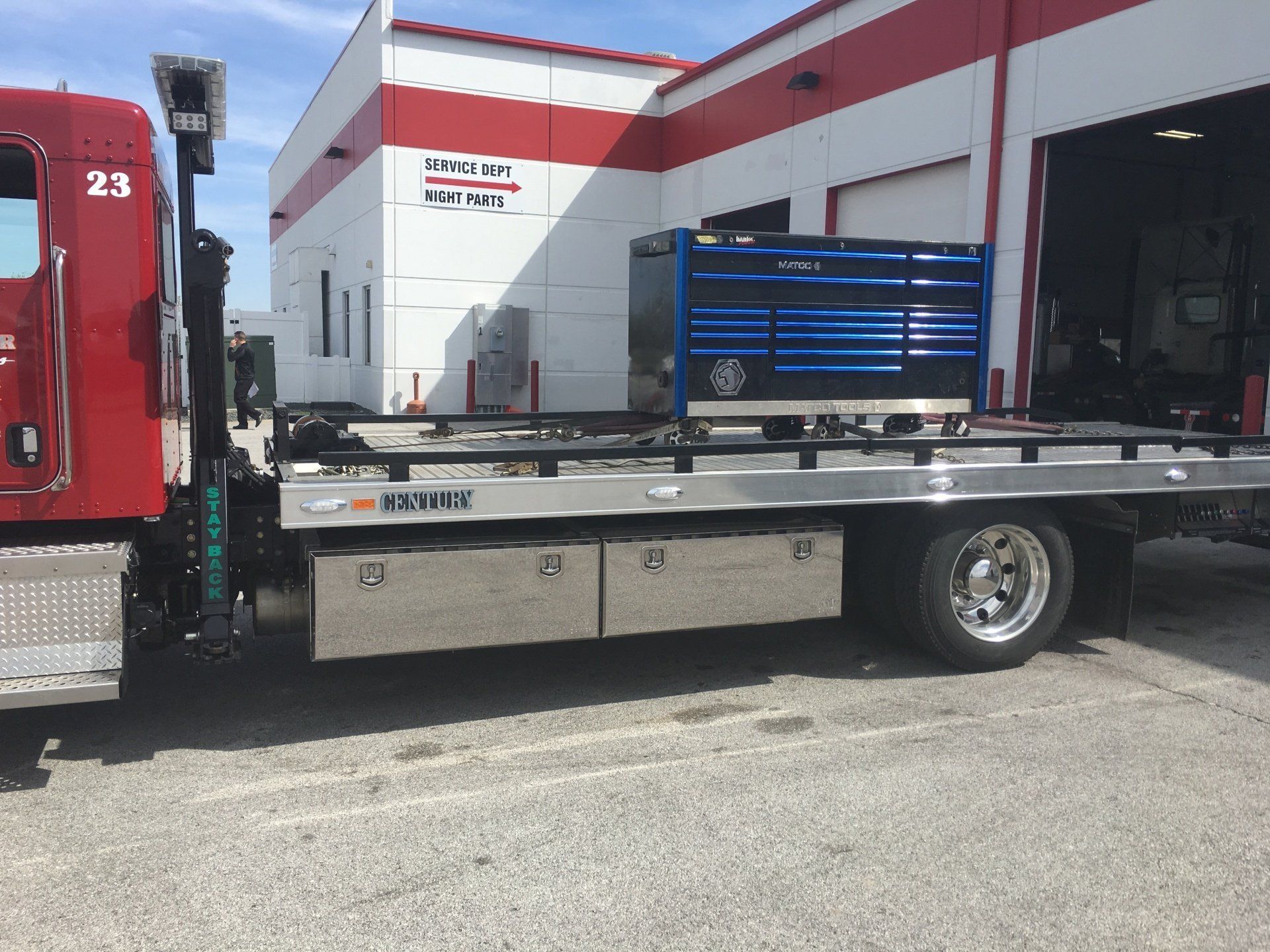 A red tow truck is parked in front of a building.