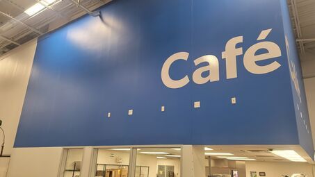 A blue sign that says cafe on it in a store.