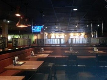 A restaurant with tables and chairs and a tv on the wall