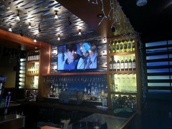 A bar with a large flat screen tv on the wall