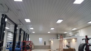 A large garage with a lot of lights on the ceiling.