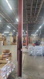 A large warehouse filled with lots of boxes and a forklift.