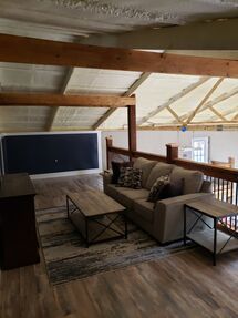 A living room with a couch , coffee table , and rug.