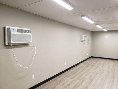 A room with two air conditioners hanging on the wall.