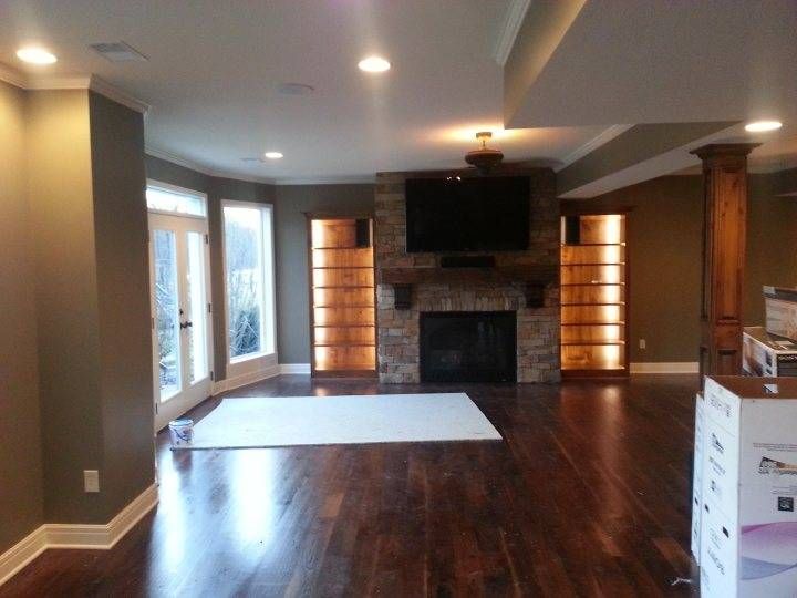 A living room with hardwood floors a fireplace and a flat screen tv