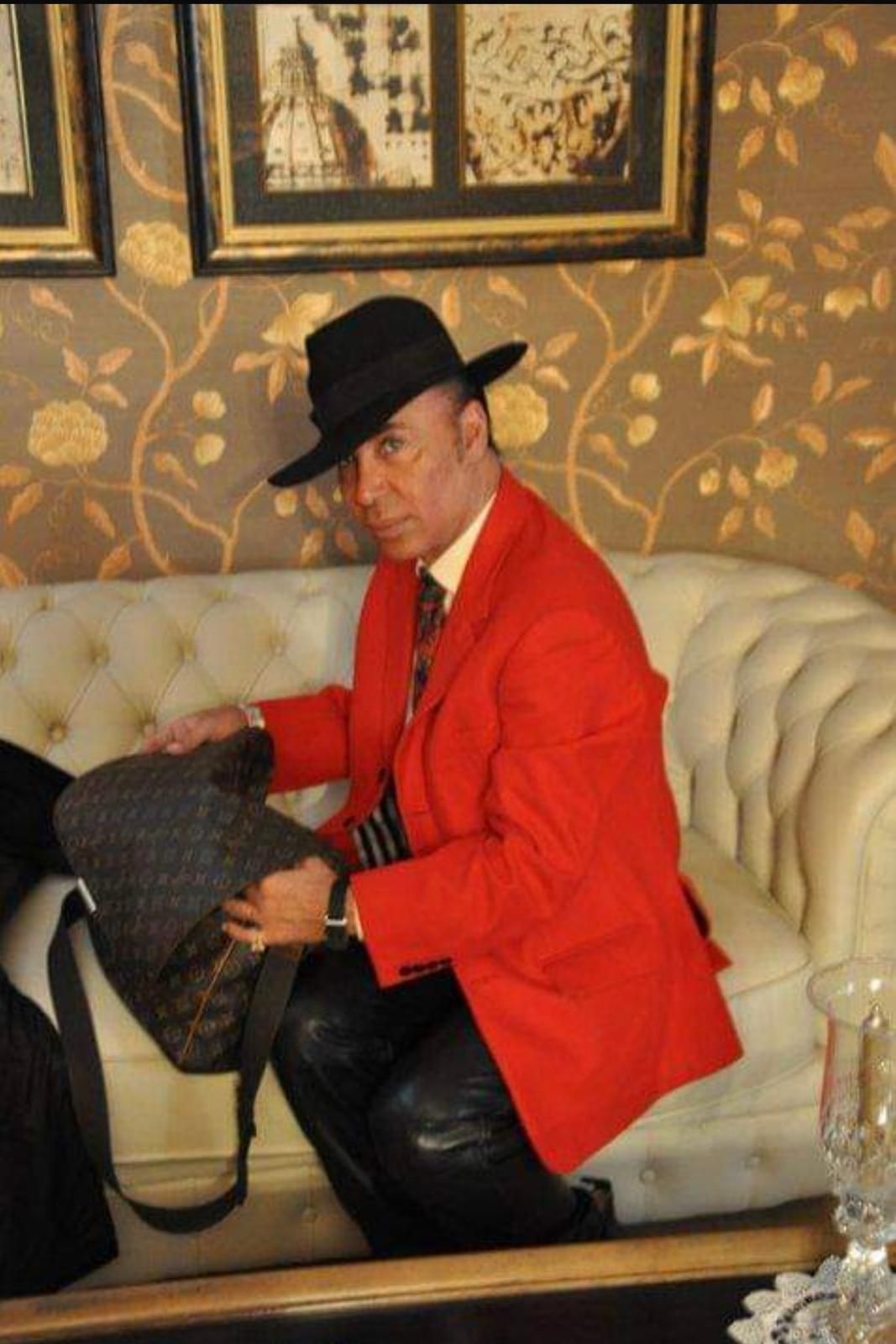 Donna con i capelli tirati indietro, che indossa un top nero, guarda direttamente la telecamera con un'espressione neutra.