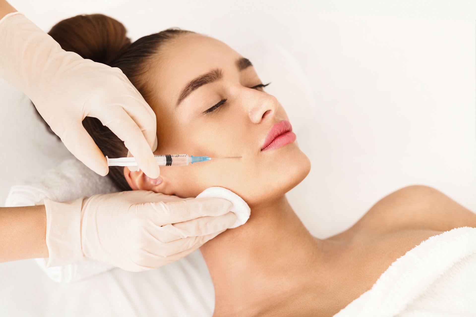 A woman is holding a syringe in her hand and looking at it.