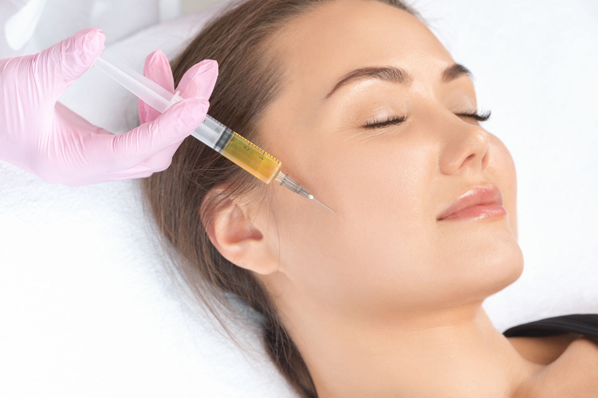 A woman is getting a facial injection in her face.