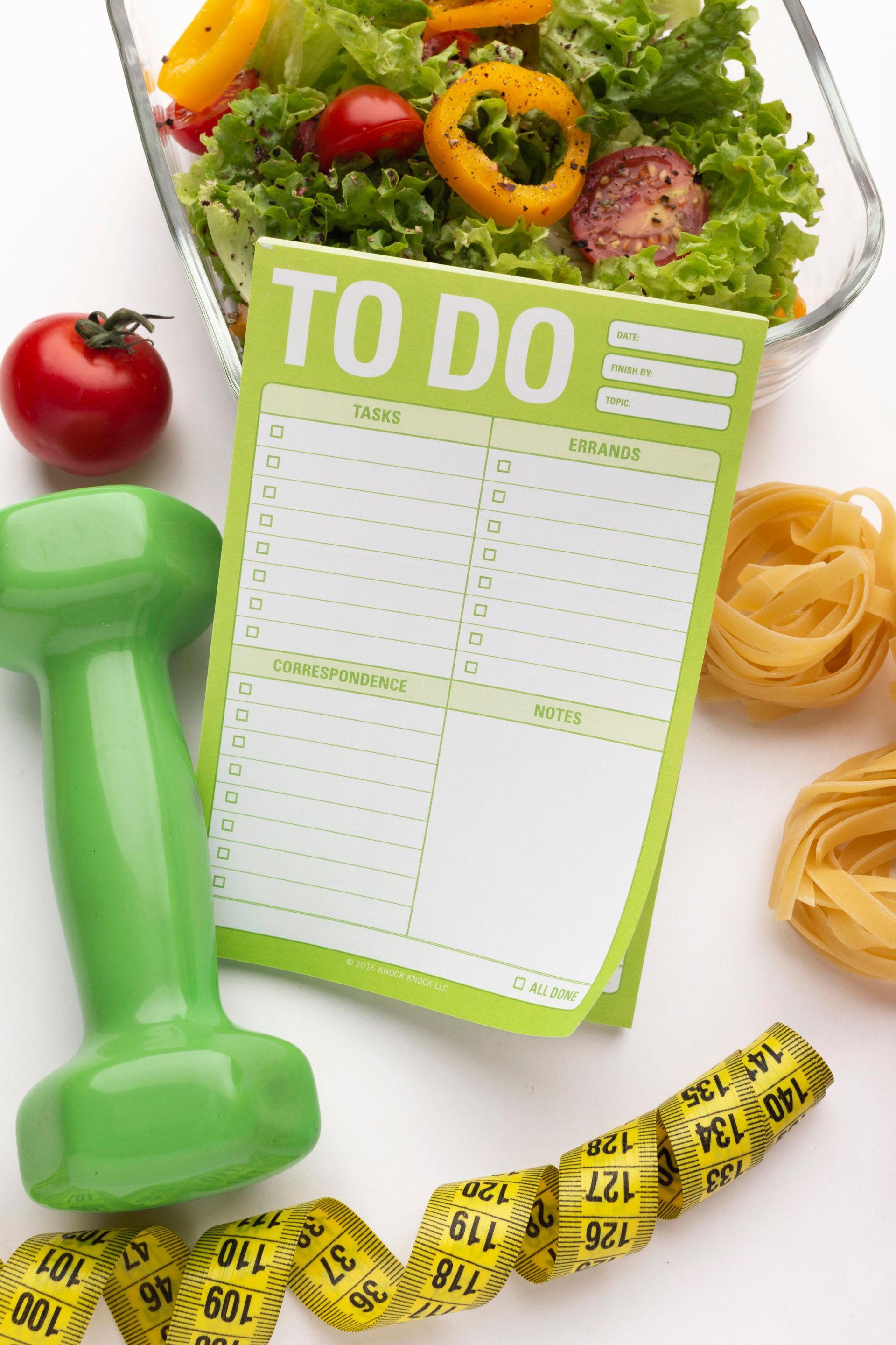 A green dumbbell sits next to a to do list