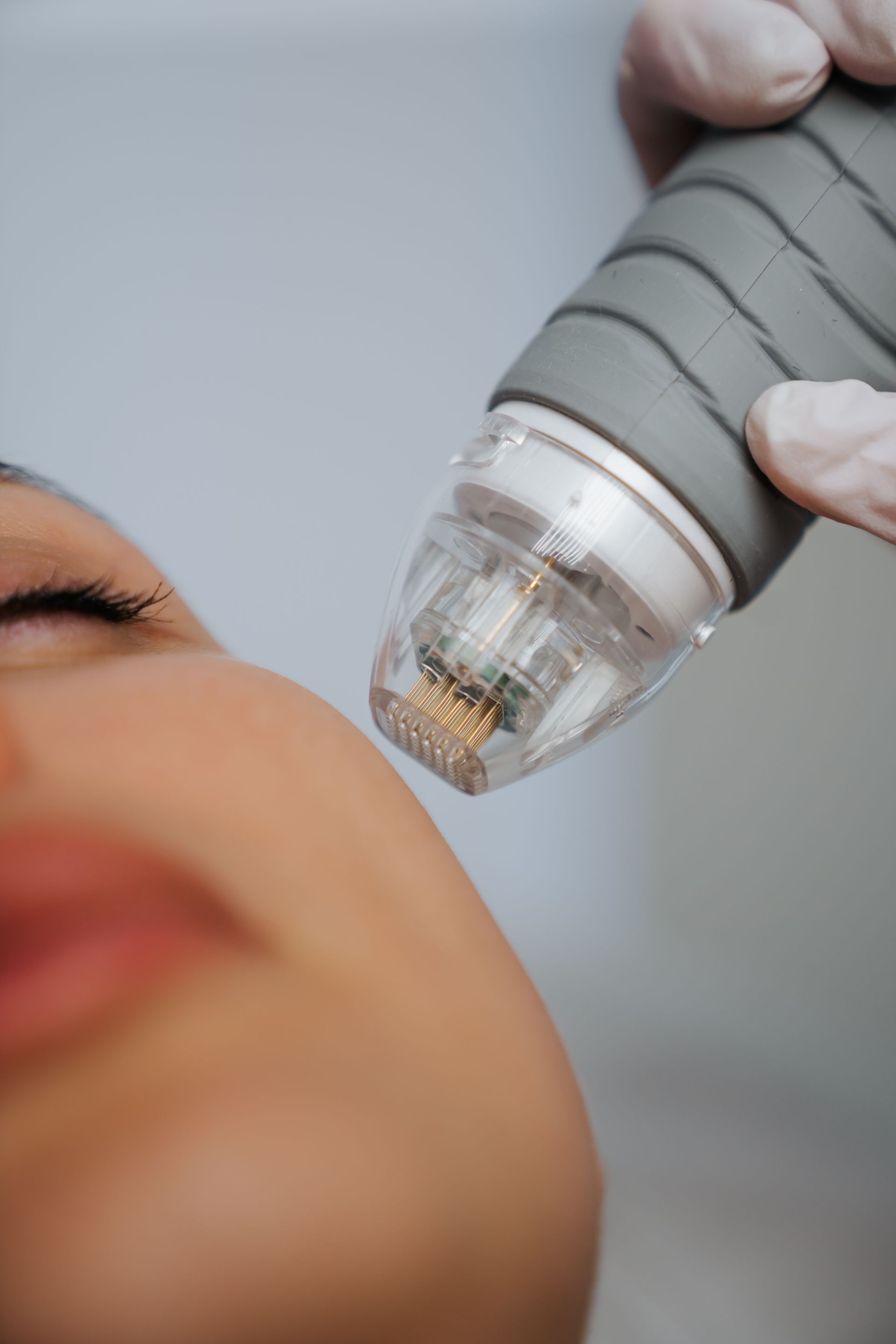 A woman is getting a facial treatment with a machine on her face.