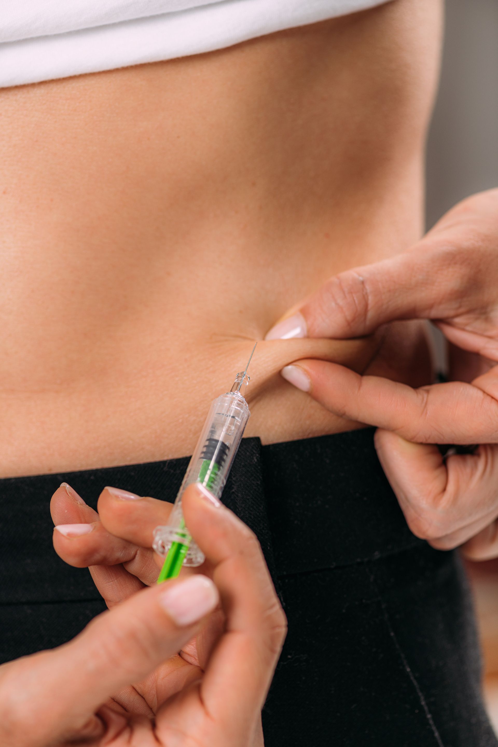 A woman is getting an injection in her back.