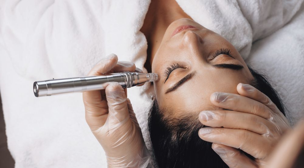 A woman is getting a microdermabrasion treatment on her face.