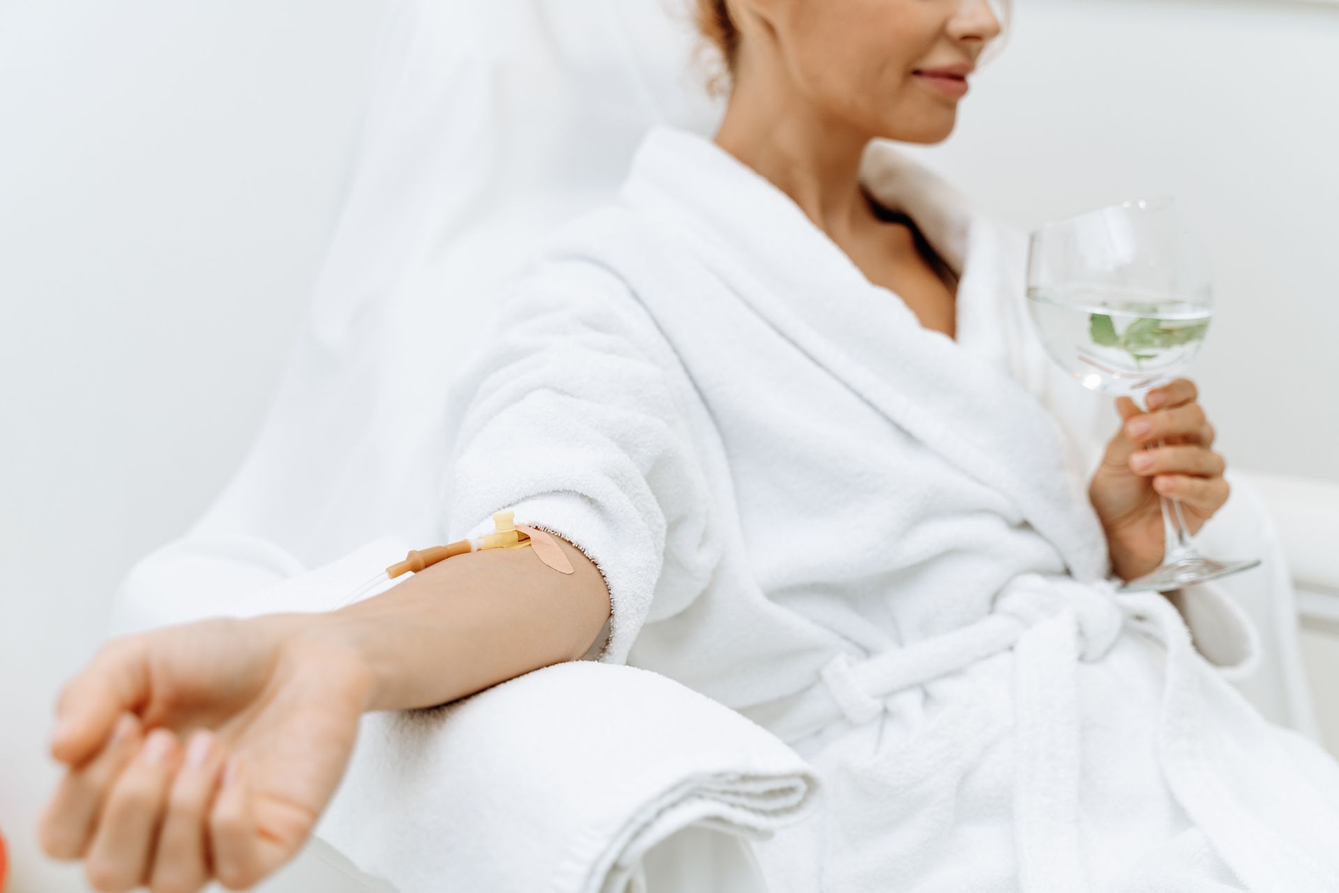 A woman in a bathrobe is sitting on a lounge chair in a spa.