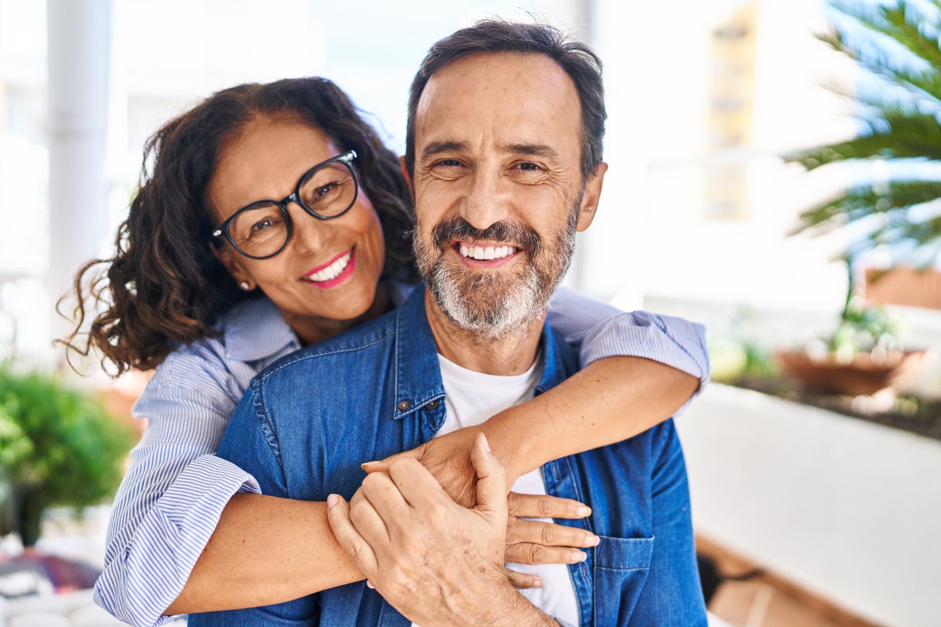 A woman is hugging a man on his back.
