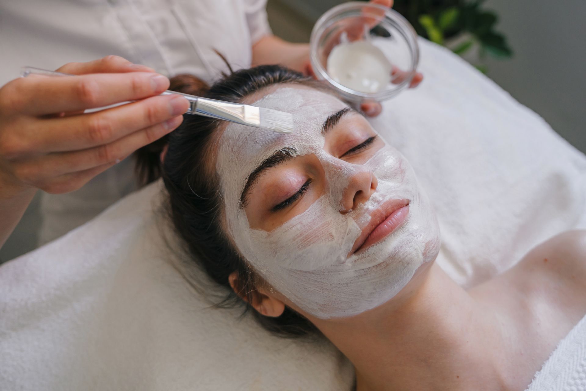 A woman is getting a facial treatment at a spa.