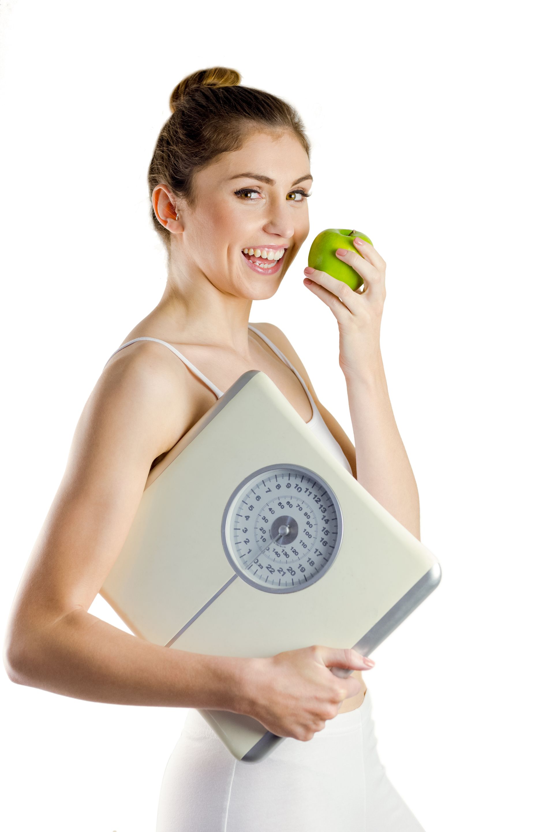 A woman is holding a scale and eating an apple.