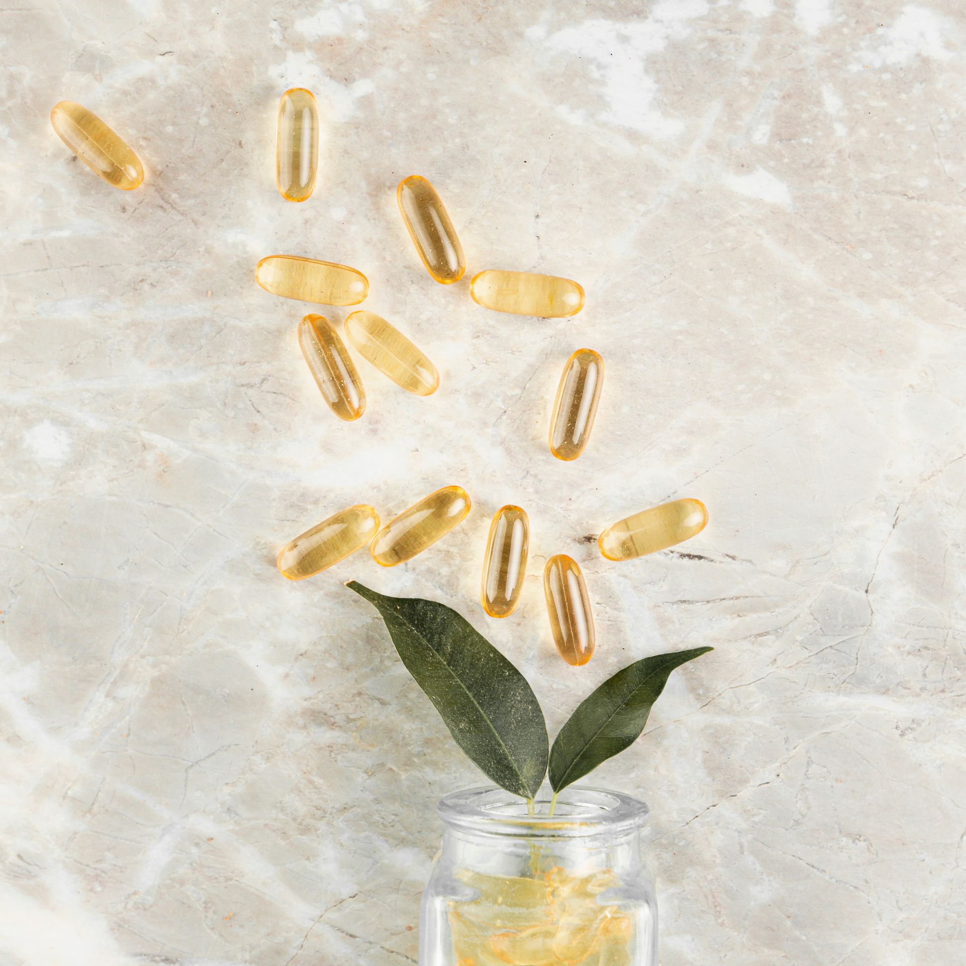 A massage table with a tray of essential oils and flowers on it.