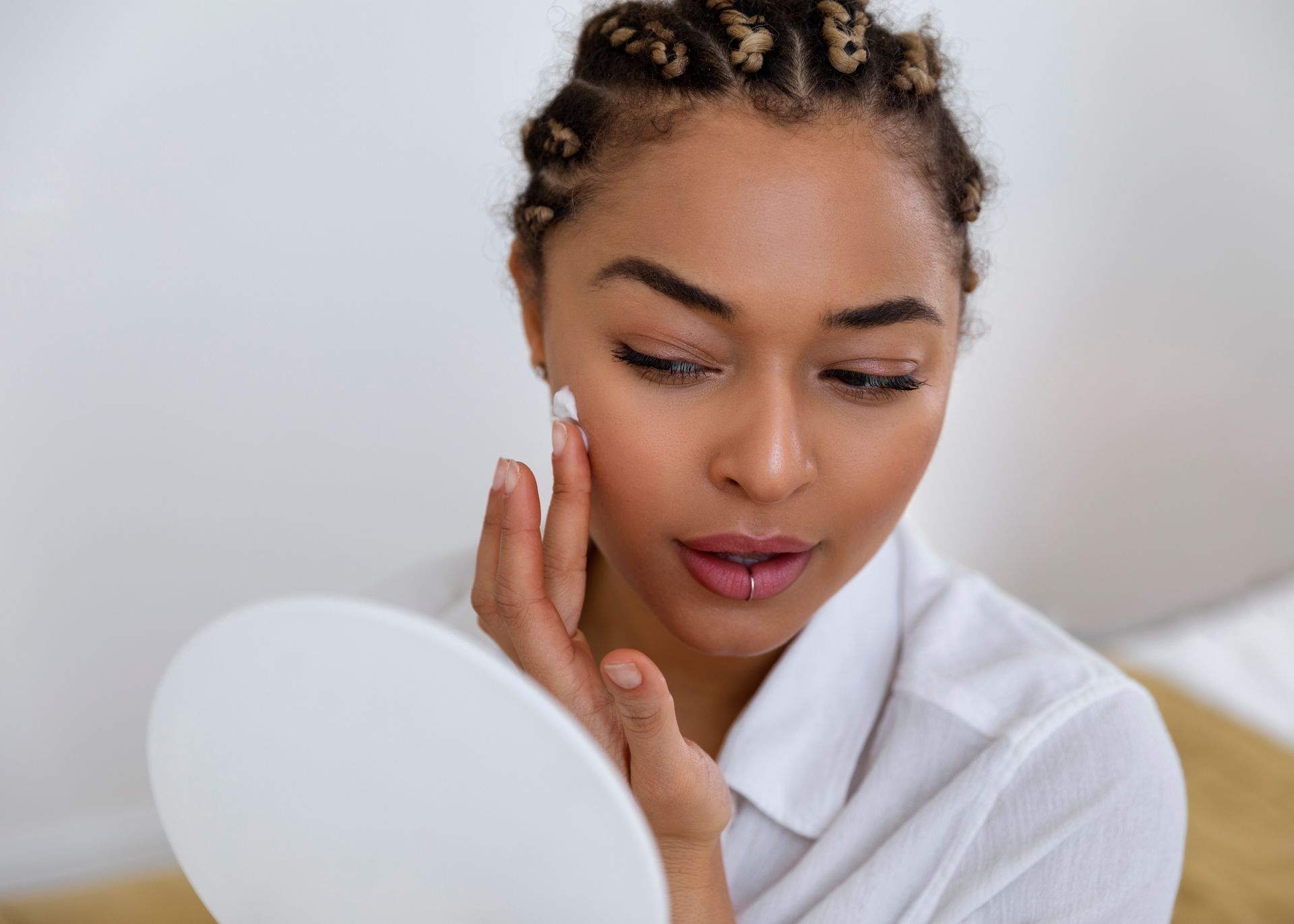A woman with a towel wrapped around her head is getting a head massage at a spa.