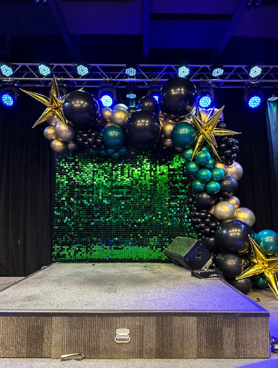 There is a stage with balloons and stars on it.