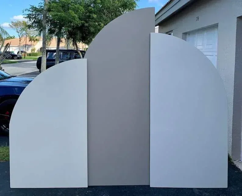 A group of white boards are sitting in a driveway in front of a garage.